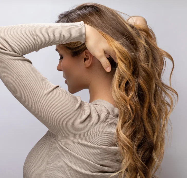 A woman pulling her hair back